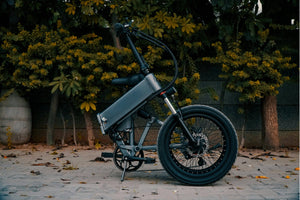 Side view of a folded electric bike with fat tyres and disc brakes, parked outdoors—ideal for city commuting, compact storage, and urban travel from Glide & Gear UK.