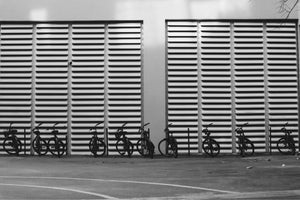Row of commuter bicycles parked outside a modern building, promoting sustainable urban transport and the Cycle to Work Scheme.