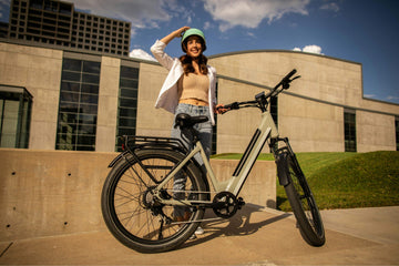 Smiling woman with a Denago electric bike in the city, enjoying a sunny day and modern urban mobility.