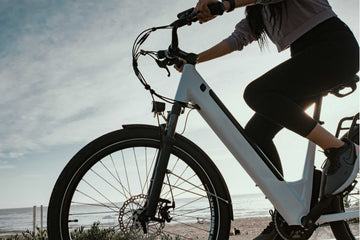 Rider on an electric bike near the beach during a coastal ride at sunset.