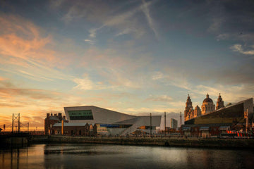 Scenic sunset view of Liverpool waterfront featuring the Museum of Liverpool, historic Great Western Railway warehouse, and Royal Liver Building domes in the background
