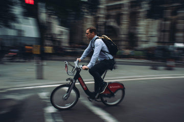Man commuting on an electric hire bike through the city, showcasing fast, efficient urban transport.