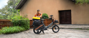 A professional using the Engwe LE20 electric cargo bike, showcasing its robust frame and storage capacity for tools.