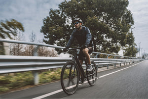 Man riding an urban electric bike on a city road, demonstrating the speed and efficiency of electric bikes for urban commuting and fitness.