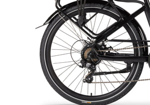 Close-up of the Wisper 705 Step-Through Electric Bike's rear wheel with Shimano gear system and durable tyres.