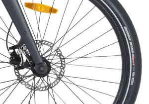 Close-up of the Wisper Tailwind City e-bike's front wheel featuring disc brakes and durable Kenda tyres at glide & gear